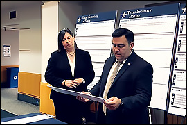 Deputy Esparza is reviewing the language that is printed on a panel that will be applied to a poster shell.