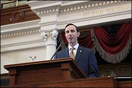 Secretary Whitley standing at a podium.