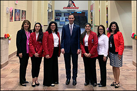 Secretary Whitley posing with high school faculty and students