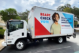 Side view of a truck that says, Ready. Check. Vote. 