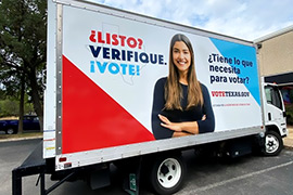 Side view of a truck that says, Ready, Check. Vote. in Spanish. 