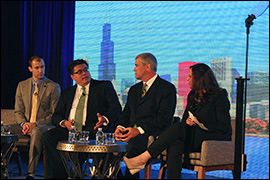 Secretary Pablos sitting with three other individuals on stage.